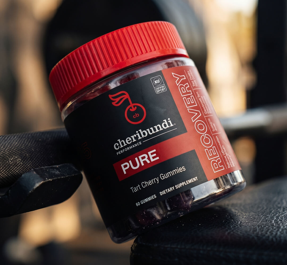 Hand holding a jar of Cheribundi Pure gummies